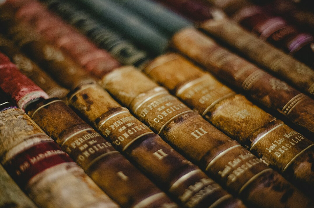 Stack of old books and archive documents on a library table