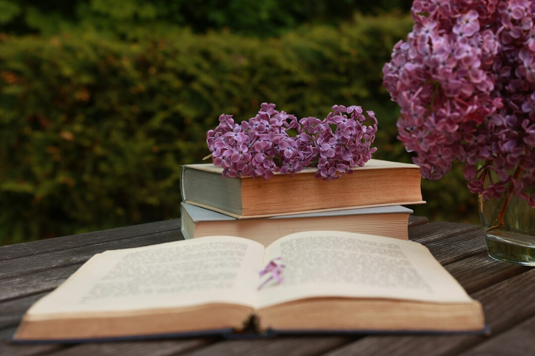 Stack of old hardcover books on a wooden table