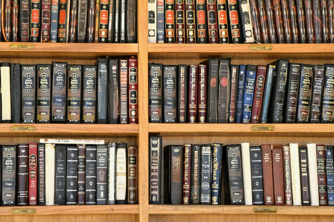 Rows of old books on wooden library shelves